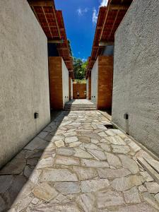 聖米格爾－杜斯米拉格里斯的住宿－NORI POUSADA，两栋建筑之间的石头人行道,以天空为背景