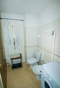 uma casa de banho com um WC e uma cortina de chuveiro em CodeminCampiglia Casa Vista Mare con Giardino em Campiglia