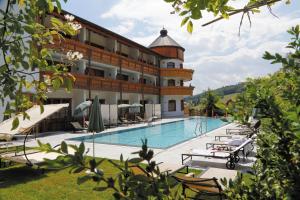 un hôtel avec une piscine et un bâtiment dans l'établissement Wellness Hotel Bayerischer Hof, à Rimbach