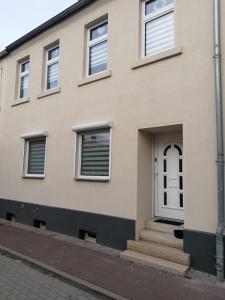 una casa con una puerta blanca y escaleras en Ferienappartement Bodekessel, en Thale