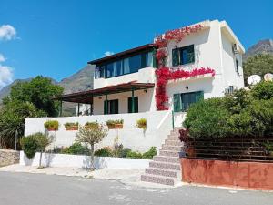 a white house with flowers on the side of it at Strofi House in Argoulés