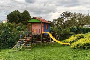 a small house with a slide and a playground at Descanso y confort 2 in La Tebaida