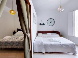 a bedroom with two beds and a clock on the wall at Dimora a Palazzo in Monopoli