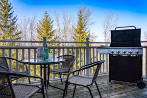 a patio with a table and chairs and a grill on a deck at Beautiful & Bright 3 Bed Townhome Near Village in Blue Mountains
