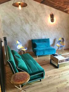ein Wohnzimmer mit einem grünen Sofa und Stühlen in der Unterkunft Romantic home with beautiful view lake of Como and Villa Oleandra in Laglio
