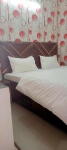 Hotel king palace في شانديغار: سرير بشرشف ووسائد بيضاء في الغرفة