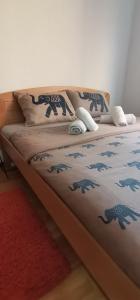 Bett in einem Zimmer mit einer Decke mit Dinosauriern drauf in der Unterkunft Apartman MAŠA in Jagodina