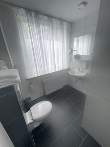 a bathroom with a white toilet and a sink at MOTELO Bielefeld - Smart HOTEL in Bielefeld