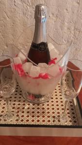 una botella de champán en un tazón con dos copas de vino en NORI POUSADA, en São Miguel dos Milagres