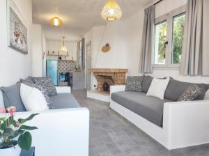 uma sala de estar com dois sofás brancos e uma lareira em Rhodes Soul luxury suites em Afantou