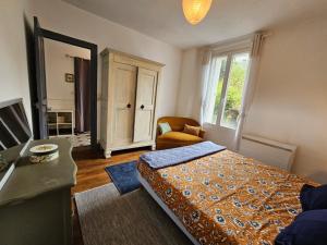 1 dormitorio con 1 cama, 1 silla y 1 ventana en L'Annexe de la corniche, en Chaumont