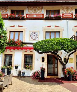 un edificio con un árbol delante de él en Alla Posta Guest House, en Garna dʼAlpago