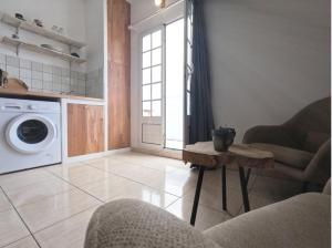ein Wohnzimmer mit einer Waschmaschine und einem Tisch in der Unterkunft Ti cocon in Le Tampon