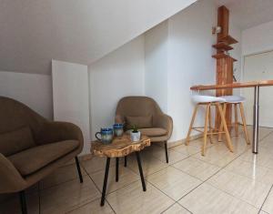 ein Wohnzimmer mit 2 Stühlen und einem Tisch in der Unterkunft Ti cocon in Le Tampon