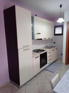 kuchnia z białymi szafkami i piekarnikiem w obiekcie Appartamento tra mare e città w mieście Vasto