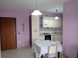 a kitchen with a table and chairs and a kitchen with purple walls at Appartamento tra città e mare in Vasto
