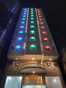 a building with colored lights on the side of it at Najmat Alnoor Almaabdah Hotel in Makkah