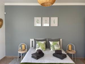 una camera da letto con un letto con tre cuscini sopra di Ocean Country Guest House Freiria a Freiria Altre 37 foto