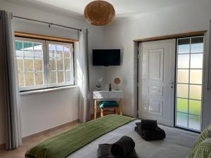 1 dormitorio con 1 cama, escritorio y ventanas en Ocean Country Guest House Freiria, en Freiria