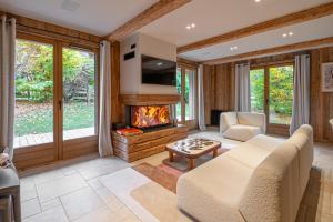 a living room with a couch and a fireplace at Chalet Isatis in Megève