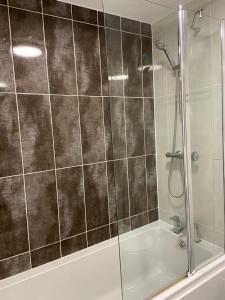 a bathroom with a shower and a bath tub at 3 bed house with parking near airport in Edinburgh