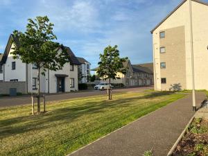 a street with houses and a car on the road at 3 bed house with parking near airport in Edinburgh