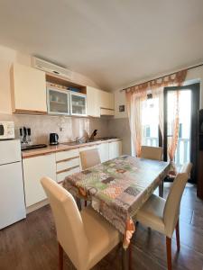 uma cozinha com mesa e cadeiras e uma cozinha com electrodomésticos brancos em VILLA MARE em Supetar
