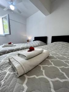 a white bedroom with a bed with towels on it at Le Lemon - 5 pers accès plage 300m - Vue mer in Bodrum City
