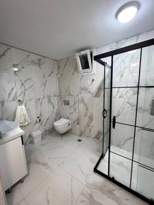 e bagno con servizi igienici, lavandino e doccia. di Le Lemon - 5 pers accès plage 300m - Vue mer a Bodrum City