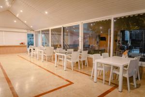 a dining room with white tables and white chairs at MiraSu Hotel in Agva