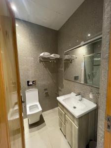 uma casa de banho com um lavatório, um WC e um espelho. em The Cocoon em Dehradun