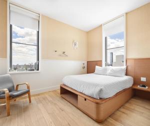 - une chambre avec un lit, une chaise et deux fenêtres dans l'établissement UNTITLED 3 Freeman Alley, à New York