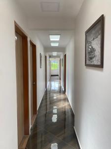 a hallway with white walls and a tile floor at HOTEL MI CASA DEL NORTE in Santa Rosa de Osos