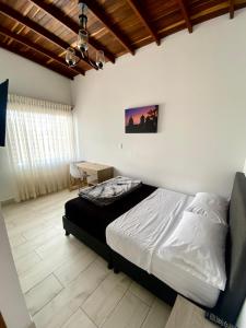 a bedroom with a bed and a desk in it at HOTEL MI CASA DEL NORTE in Santa Rosa de Osos