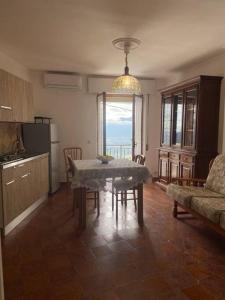 Su Murcone Appartamento Baunei في بوناي: مطبخ وغرفة طعام مع طاولة وأريكة