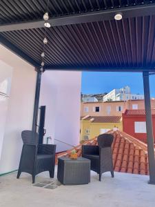 a patio with two chairs and a television on a roof at Casa Mi Mona in Santa Cruz de la Palma