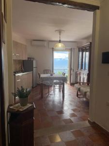 a living room with a table and a kitchen at Su Murcone Appartamento Baunei in Baunei +11 photos