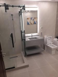 a bathroom with a sink and a toilet and a mirror at Aseel Hotel Apartment in Jazan