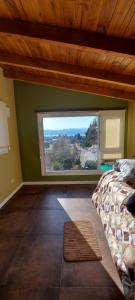 a bedroom with a bed and a large window at Maiten Apartamentos in San Carlos de Bariloche