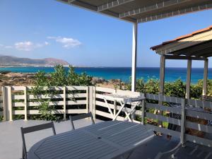 um pátio com uma mesa e vista para o oceano em Sunset Bungalows em Falasarna