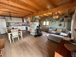 eine Küche und ein Wohnzimmer mit einem Sofa und einem Tisch in der Unterkunft Domek letniskowy Opowieści z Narie Kretowiny in Kretowiny