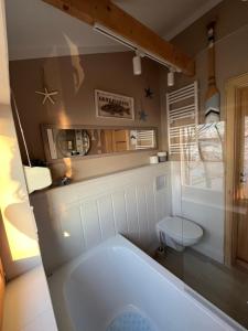 ein Bad mit einer Badewanne und einem WC in der Unterkunft Domek letniskowy Opowieści z Narie Kretowiny in Kretowiny