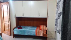 ein kleines Schlafzimmer mit einem Bett und weißen Schränken in der Unterkunft Fior di sole in Maracalagonis