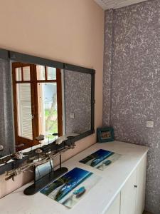 La salle de bains est pourvue d'un lavabo et d'un grand miroir. dans l'établissement Sun Helios Garden Aparthotel, à Thasos