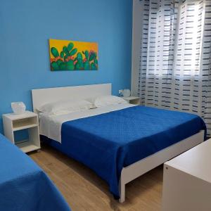 羅卡盧梅拉的住宿－Blue Sicily Apartment，蓝色的卧室,配有床和蓝色的墙壁