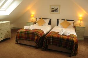 two twin beds in a room with two lamps at Serendipity in Kirkcudbright