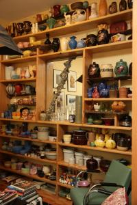 a shelf filled with lots of bowls and vases at Ray's Bucktown Bed and Breakfast in Chicago