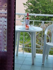 a white table with a bottle of wine and a glass at Sun Helios Garden Aparthotel in Limenas