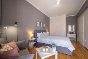 a bedroom with a bed and a couch at Izabella Guest House in Nafplio