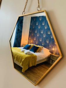 espejo reflejo de una cama en una habitación en La Maison d'Emilie - Chambres d'hôtes, en Chaumes-en-Brie